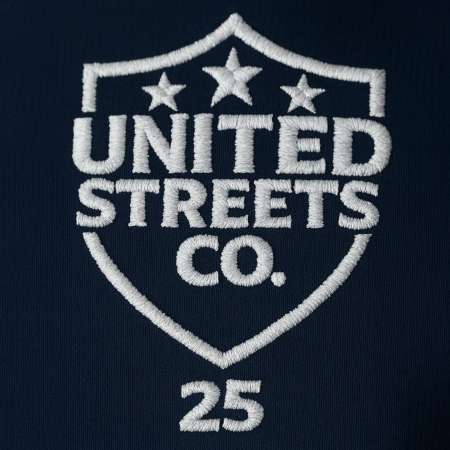 Embroidered logo of United Streets Co. on a dark background